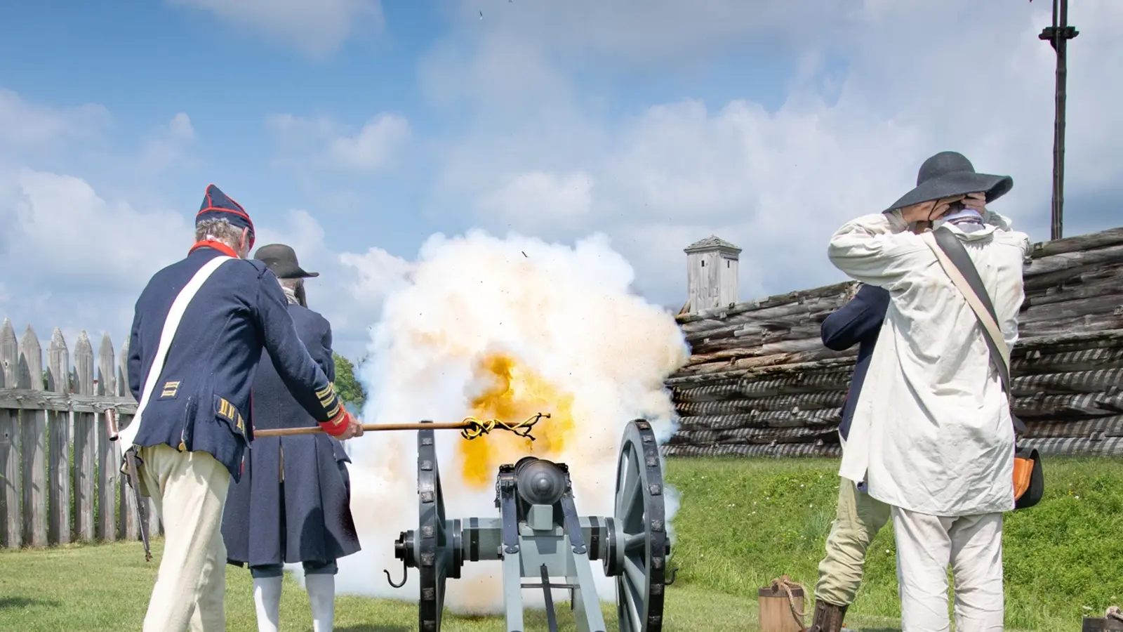 Costumed interpreters firing a cannon inside Fort Stanwix
